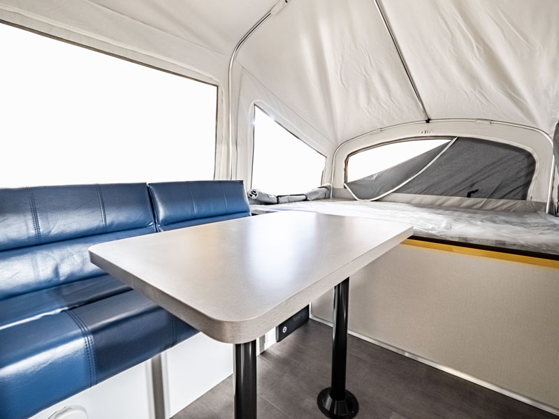 inside the aire80 tent camper with table and sofa